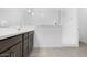 Bathroom featuring stylish brown cabinets, a white countertop, and a sleek glass-enclosed shower, designed for modern living at 16784 W Hope Dr, Surprise, AZ 85388