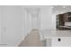 Bright hallway leading to a modern kitchen with stainless steel appliances and sleek cabinets, designed for convenient living at 16784 W Hope Dr, Surprise, AZ 85388