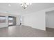 Spacious living area features neutral paint, tiled floors, a modern chandelier, and a slider to the backyard at 16784 W Hope Dr, Surprise, AZ 85388