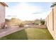 A sunny backyard with artificial grass and desert landscaping has a view of a sparkling pool at 19276 N 90Th Pl, Scottsdale, AZ 85255