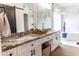 Luxurious bathroom with granite countertops, custom cabinets, dual sinks, and a soaking tub at 19276 N 90Th Pl, Scottsdale, AZ 85255