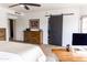 Bright bedroom featuring a ceiling fan, work space, sliding barn door to walk-in closet at 19276 N 90Th Pl, Scottsdale, AZ 85255