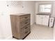 Well-lit laundry room featuring custom cabinets, sleek countertops and charming patterned tile flooring at 19276 N 90Th Pl, Scottsdale, AZ 85255