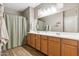 Bathroom featuring a double sink vanity with wood cabinets, mirror, and shower at 2237 S Jacana Ln, Gilbert, AZ 85295