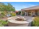 Relaxing backyard featuring a fire pit with built-in seating, lush landscaping, and a refreshing pool at 2239 N Calvin --, Mesa, AZ 85207