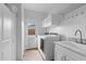 Well-organized laundry room with white cabinets, a utility sink, and direct access to the outdoors at 2239 N Calvin --, Mesa, AZ 85207