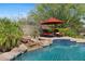 Backyard oasis featuring a sparkling pool, desert landscaping, a small waterfall, and lounge area at 2239 N Calvin --, Mesa, AZ 85207