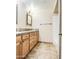Bathroom featuring dual sinks, stone counters, tile floors, and decorative mirrors and light fixtures at 2329 W Keating Ave, Mesa, AZ 85202