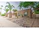 Attractive home exterior featuring desert landscaping with decorative rocks and mature palm and shade trees at 2329 W Keating Ave, Mesa, AZ 85202