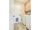 Functional laundry room with a door to the backyard and washer and dryer, and upper cabinets at 2329 W Keating Ave, Mesa, AZ 85202