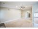 Spacious living room with a neutral color palette, ceiling fan, and arched doorway leading to the entrance at 2329 W Keating Ave, Mesa, AZ 85202