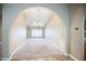 Elegant living room with neutral carpet, arched doorways, chandelier lighting and large window at 2329 W Keating Ave, Mesa, AZ 85202