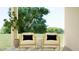 Comfortable outdoor seating area with stylish chairs and a side table, surrounded by lush greenery at 23398 W Sonrisas St, Buckeye, AZ 85326