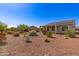 Backyard desert landscaping with covered patio, solar panels on roof at 26753 W Zachary Dr, Buckeye, AZ 85396