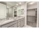 Bright bathroom featuring double sink vanity with stone countertop and a walk-in closet at 26753 W Zachary Dr, Buckeye, AZ 85396