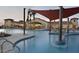 Resort-style community pool featuring unique shade structures and palm trees, great for relaxing at 26753 W Zachary Dr, Buckeye, AZ 85396