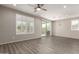 Open living room featuring wood floors, shuttered windows, and sliding glass doors at 26753 W Zachary Dr, Buckeye, AZ 85396