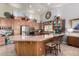 Open kitchen boasts an island with seating, modern appliances, and wooden cabinetry at 3166 N 158Th Ave, Goodyear, AZ 85395