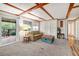 Living room with carpet, deck access, view of the exterior, and beamed ceilings at 33601 N Rifleman Rd, Cave Creek, AZ 85331
