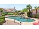 Backyard with pool featuring rock waterfall, desert landscaping, and patio lighting at 4428 E Yawepe St, Phoenix, AZ 85044