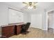 Office/bedroom space with a large desk, wood-look flooring, and a ceiling fan at 4428 E Yawepe St, Phoenix, AZ 85044