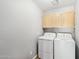 Bright laundry room features a white washer and dryer, plus storage cabinets for added convenience at 4428 E Yawepe St, Phoenix, AZ 85044