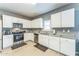 Bright kitchen with white cabinets, stainless steel appliances, and granite countertops at 45173 W Sandhill Rd, Maricopa, AZ 85139