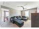 Relaxing living room features plush dark-gray sectional sofa, carpet, and a ceiling fan at 45173 W Sandhill Rd, Maricopa, AZ 85139