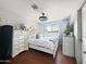 Bedroom with dark wood look floors, white bed, blue accents, and lots of natural light at 4639 W Keim Dr, Glendale, AZ 85301