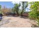 Wide shot of the backyard shows the dirt yard, some fruit laying on the ground and a trampoline at 4719 N 70Th St, Scottsdale, AZ 85251