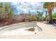 This backyard features an empty pool that needs repair with a brick wall and mature landscaping at 4719 N 70Th St, Scottsdale, AZ 85251