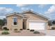 Tan single-story home featuring a two-car garage, desert landscaping, and a welcoming front entrance at 47705 W Moeller Rd, Maricopa, AZ 85139