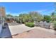The backyard featuring a covered patio area, desert landscaping, and mature trees at 5228 E Des Moines St, Mesa, AZ 85205