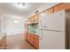 The kitchen features wooden cabinets, a white refrigerator, and a vintage oven at 5228 E Des Moines St, Mesa, AZ 85205