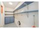The laundry room boasts blue shelving and a cabinet, offering ample storage for laundry essentials at 5228 E Des Moines St, Mesa, AZ 85205