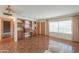 Living room with wood flooring, large windows with curtains, and built-in shelving units at 5228 E Des Moines St, Mesa, AZ 85205
