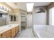 Bright bathroom features a dual sink vanity, a separate shower, and a large soaking tub at 6126 W Paradise Ln, Glendale, AZ 85306