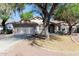 Charming single-story home with a well-manicured front yard and mature trees providing ample shade at 6126 W Paradise Ln, Glendale, AZ 85306