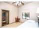 A bright bedroom featuring a window, ceiling fan, tropical room in the background, desk and a bed at 6334 E Albany St, Mesa, AZ 85205