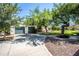 Two-car garage with green doors and mature landscaping on a large lot with gravel drive at 6334 E Albany St, Mesa, AZ 85205