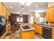 Open kitchen with hardwood cabinets, granite counters, tile flooring, and eat in dining area at 6334 E Albany St, Mesa, AZ 85205