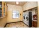 Spacious laundry room featuring a window, storage cabinets, tile flooring and front loading washer and dryer at 6334 E Albany St, Mesa, AZ 85205