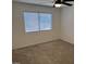 This bedroom features neutral carpet, a ceiling fan, and natural light from the window at 7040 W Olive Ave # 94, Peoria, AZ 85345