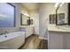 Bathroom featuring a modern soaking tub, and double vanity with framed mirrors at 710 W Ardmore Rd, Phoenix, AZ 85041