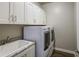 Bright laundry room with large cabinets over a modern washer and dryer, and sink at 710 W Ardmore Rd, Phoenix, AZ 85041