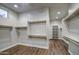 Bright walk-in closet with custom white shelving and dark wood-look floors at 710 W Ardmore Rd, Phoenix, AZ 85041