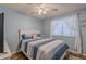 Comfortable bedroom with blue walls, ceiling fan, and a window letting in natural light at 7940 W Willow Ave, Peoria, AZ 85381