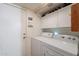 Clean laundry room with a washer, dryer, and ample storage space at 7940 W Willow Ave, Peoria, AZ 85381