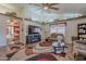 Inviting living room with vaulted ceilings, a cozy fireplace, stylish decor, and a ceiling fan for added comfort at 7940 W Willow Ave, Peoria, AZ 85381