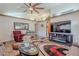 Inviting living room with vaulted ceilings, a cozy fireplace, stylish decor, and a ceiling fan for added comfort at 7940 W Willow Ave, Peoria, AZ 85381